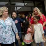 FILE: Laurie Holt, left, walks out of the airport with her son, Josh Holt, walking behind her, after returning to Salt Lake City on Monday, May 28, 2018. Josh Holt and his Venezuelan wife were locked in a Caracas jail alongside some of the country's most-hardened criminals - and President Nicolas Maduro's top opponents - for what the U.S. government argued were bogus charges of stockpiling weapons. (AP Photo/Kim Raff)