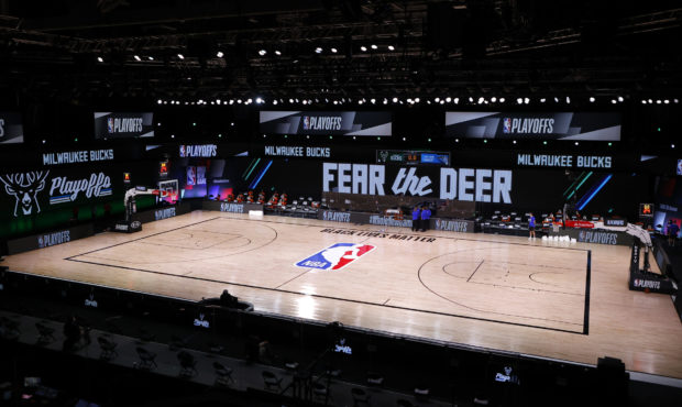 Referees huddle on an empty court at game time of a scheduled game between the Milwaukee Bucks and ...