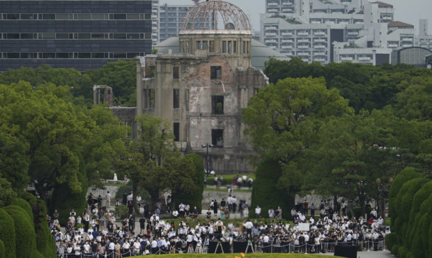 Visitors observe a minute of silence for the victims of the atomic bombing, at 8:15am, the time ato...