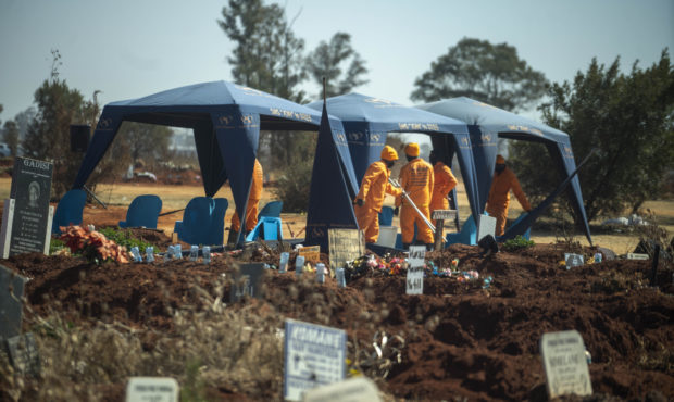 Workers prepare for a burial at the Olifantsveil Cemetery outside Johannesburg, South Africa, Thurs...