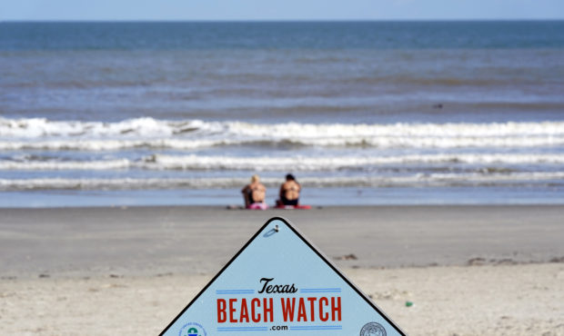 Beachgoers sit on the beach Tuesday, Aug. 25, 2020, in Galveston, Texas, as Hurricane Laura heads t...