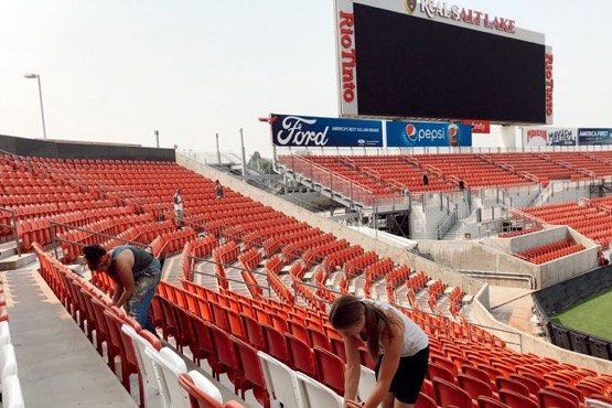 (Workers at Rio Tinto Stadium placing social distance reminders on each seat.  Courtesy, Taran Meye...