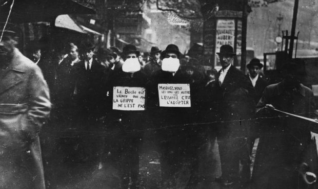 1st March 1919:  Two men wearing and advocating the use of flu masks in Paris during the Spanish fl...
