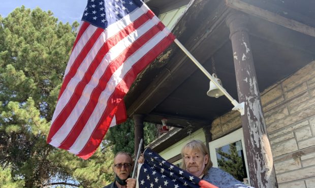 (Paul Hultgren, left, and LeJune Timmerman, right, standing under their new American flag.  Hultgre...