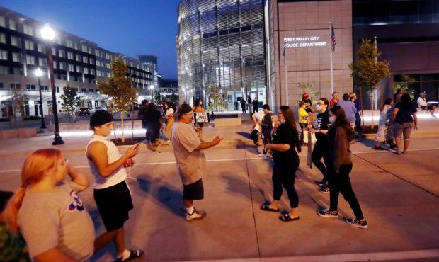 Protesters walk around after their demonstration at the West Valley City Police Department was disr...