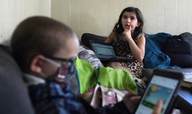 Third grade student Elena thinks while reciting multiplication tables, as her brother Wyatt reviews...