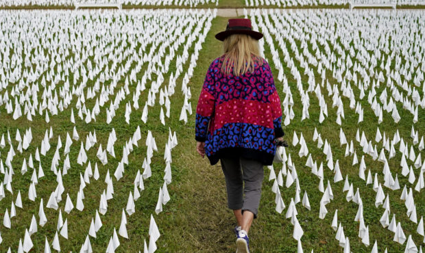FILE - In this Oct. 27, 2020, Artist Suzanne Brennan Firstenberg walks among thousands of white fla...