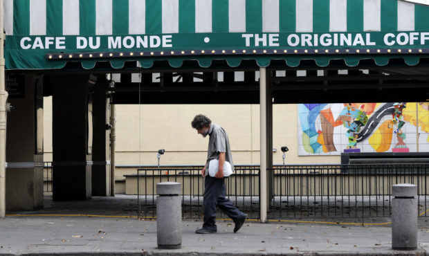 FILE - In this March 27, 2020, file photo, a man walks past the Cafe Du Monde restaurant, which was...