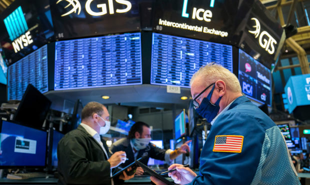 In this photo provided by the New York Stock Exchange, James Dresch, right, works with fellow trade...