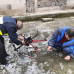 In this Dec. 10, 2020, photo released by Blue Sky Rescue of Zhong County, workers prepare a drone equipped with a flamethrower at a village in Zhong county near Chongqing municipality in southwestern China. The drone has been converted into a flying flamethrower in central China in a fiery campaign to eradicate more than 100 wasp nests. (Blue Sky Rescue of Zhong County via AP)