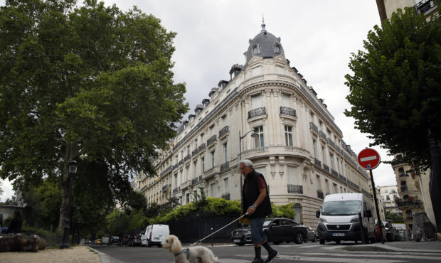 FILE - In this Aug.13, 2019 file photo, a man walks his dog next to an apartment building owned by ...