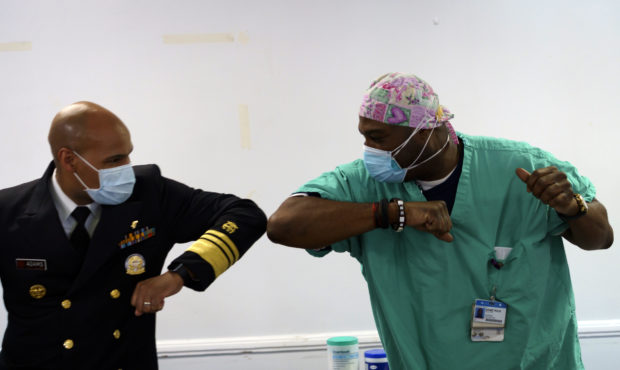 Surgeon General of the U.S. Jerome Adams, left, elbow-bumps Emergency Room technician Demetrius Mca...
