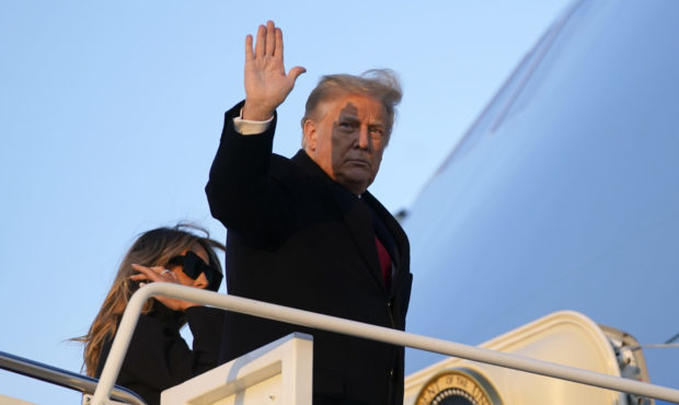 President Donald Trump waves as he boards Air Force One at Andrews Air Force Base, Md., Wednesday, ...