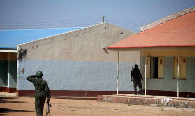 NIgerian soldiers walk inside the Government Science where gunmen abducted students in Kankara, in ...