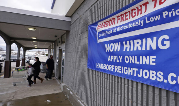 FILE - In this Dec. 10, 2020, file photo, a "Now Hiring" sign hangs on the front wall of a Harbor F...