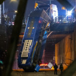 A bus in New York City careened off a road in the Bronx neighborhood of New York is seen left dangling from an overpass Friday, Jan. 15, 2021, after a crash late Thursday that left the driver in serious condition, police said. (AP Photo/Craig Ruttle)
