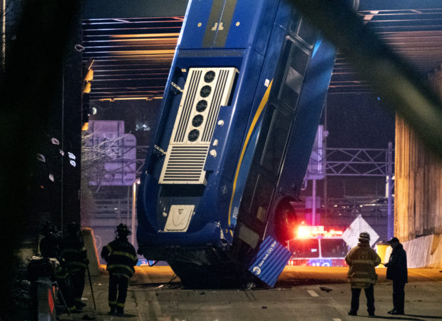 city bus hangs off overpass