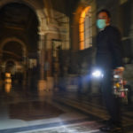 Gianni Crea, the Vatican Museums chief "Clavigero" key-keeper, holds a torch and a bunch of keys as he walks to open the museum's rooms and sections, at the Vatican, Monday, Feb. 1, 2021. Crea is the “clavigero” of the Vatican Museums, the chief key-keeper whose job begins each morning at 5 a.m., opening the doors and turning on the lights through 7 kilometers of one of the world's greatest collections of art and antiquities. The Associated Press followed Crea on his rounds the first day the museum reopened to the public, joining him in the underground “bunker” where the 2,797 keys to the Vatican treasures are kept in wall safes overnight. (AP Photo/Andrew Medichini)