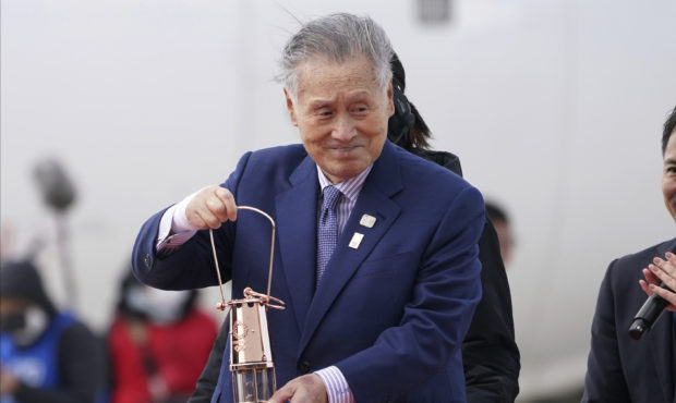 FILE - In this March 20, 2020, file photo, Tokyo 2020 Olympics chief Yoshiro Mori carries the Olymp...