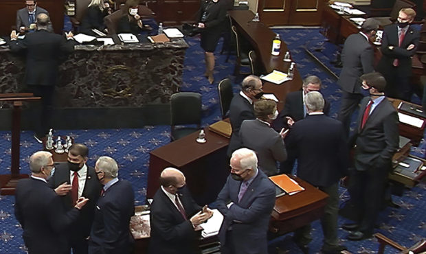 In this image from video, Republican senators and staff talk on the floor after a vote on the motio...