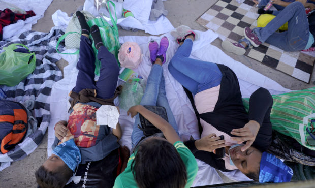 Migrants rest in a gazebo at a park after a large group of deportees were pushed by Mexican authori...