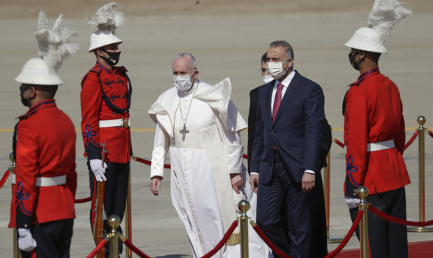 Pope Francis is flanked by Iraqi Prime Minister Mustafa al-Kadhimi upon his arrival at Baghdad's in...