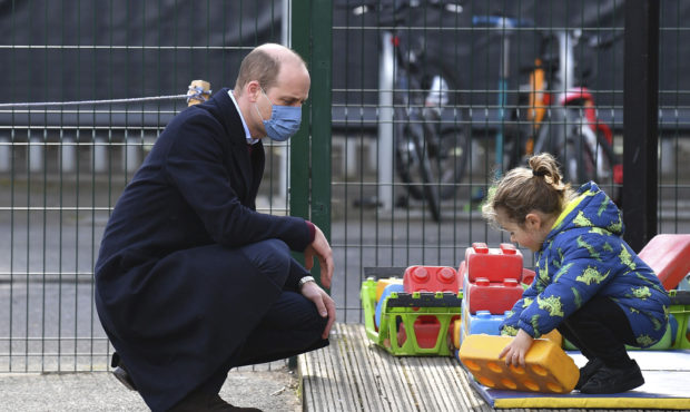 Britain's Prince William watches a child in the playground during a visit with Kate, Duchess of Cam...
