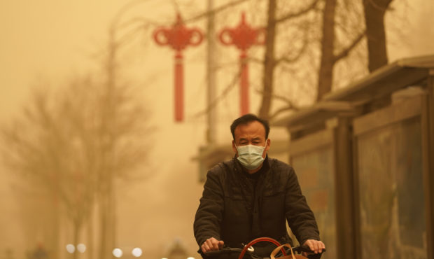 A resident rides through a sandstorm in Beijing, Monday, March 15, 2021. The sandstorm brought a ti...