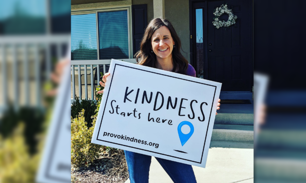A woman holds a Provo Kindness "Kindness starts here" sign. Courtesy Provo Kindness Facebook...