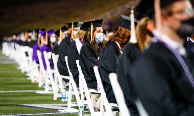 FILE -- Students sit and put their masks on during the spring and summer graduation ceremonies at S...