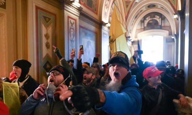 A man wearing an Oath Keepers hat yells in the hallways of the Capitol during the invasion by riote...