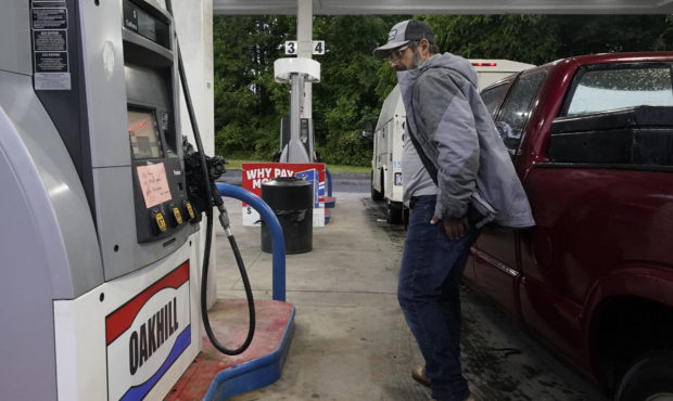 A customer looks at a hand written sign posted on a gas pump, showing that the service station is o...