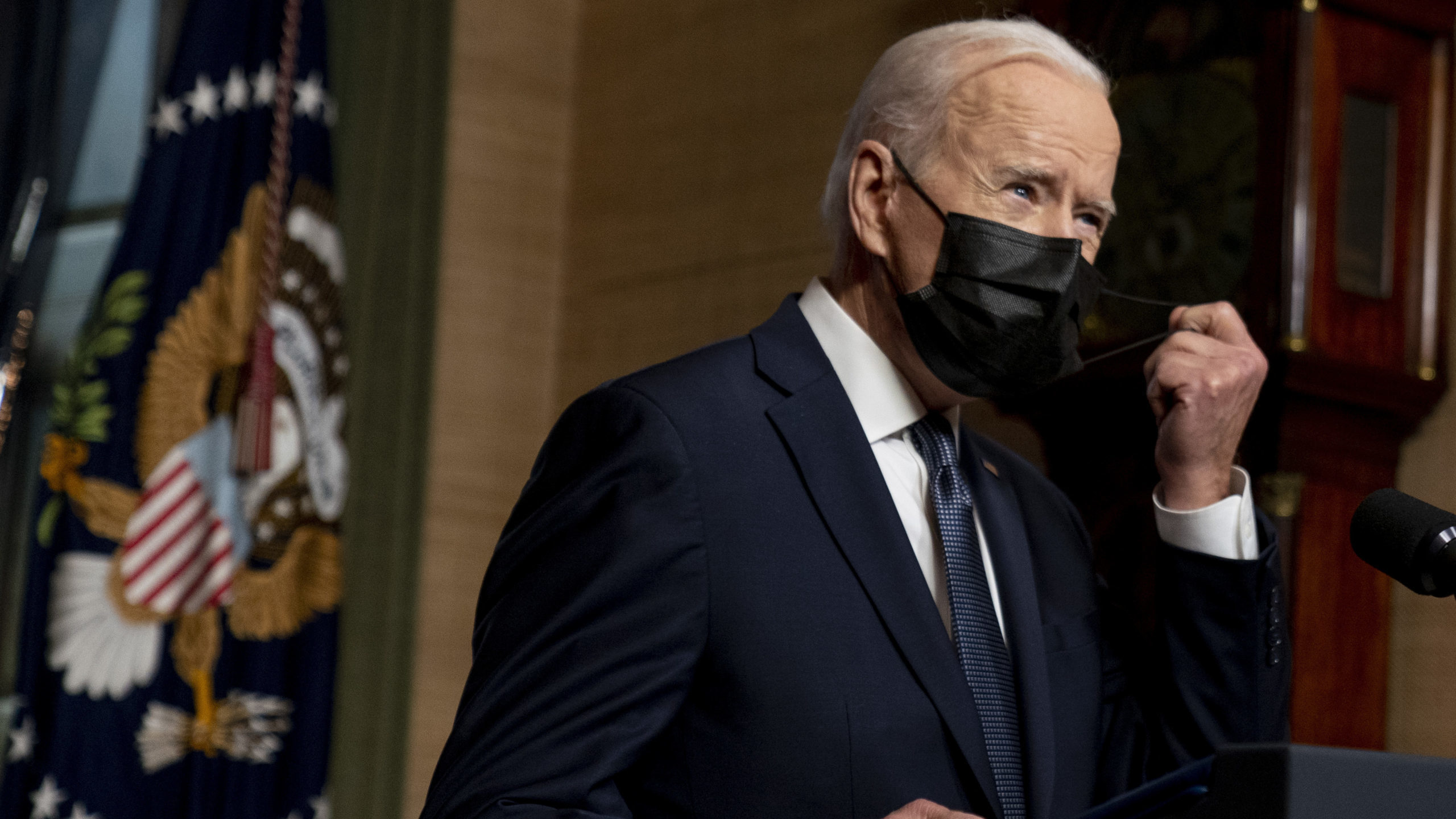FILE - In this Wednesday, April 14, 2021, file photo, President Joe Biden removes his mask to speak...