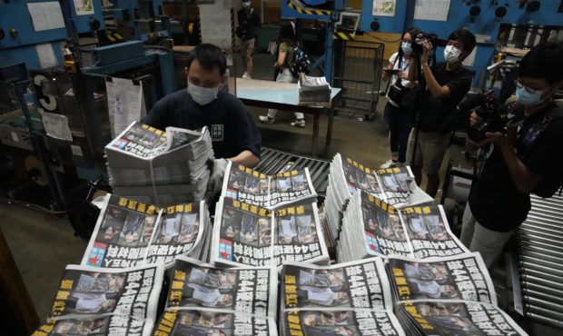 FILE - In this Friday, June 18, 2021, file, a worker packs copies of the Apple Daily newspaper at t...