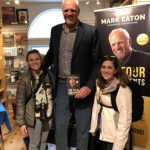 Mark Eaton, 7-foot-4, showed off his height at a book signing by posing next to KSL producer Kira Hoffelmeyer, right, and a friend. Photo: KSL NewsRadio
