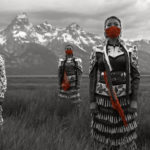 Jingle Dress dancers Erin Tapahe, Joanni Begay, Sunni Bebay and Dion Tapahe stand in front of the Grand Teton wearing red masks as part of the #WhyWeWearRed campaign to draw attention to violence against Indigenous women. Photo: Eugene Tapahe -- Art Heals: The Jingle Dress Project @thejingledressproject / Instagram