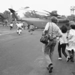 Americans and Vietnamese run for a U.S. Marine helicopter in Saigon during the evacuation of the city, April 29, 1975. (AP Photo)