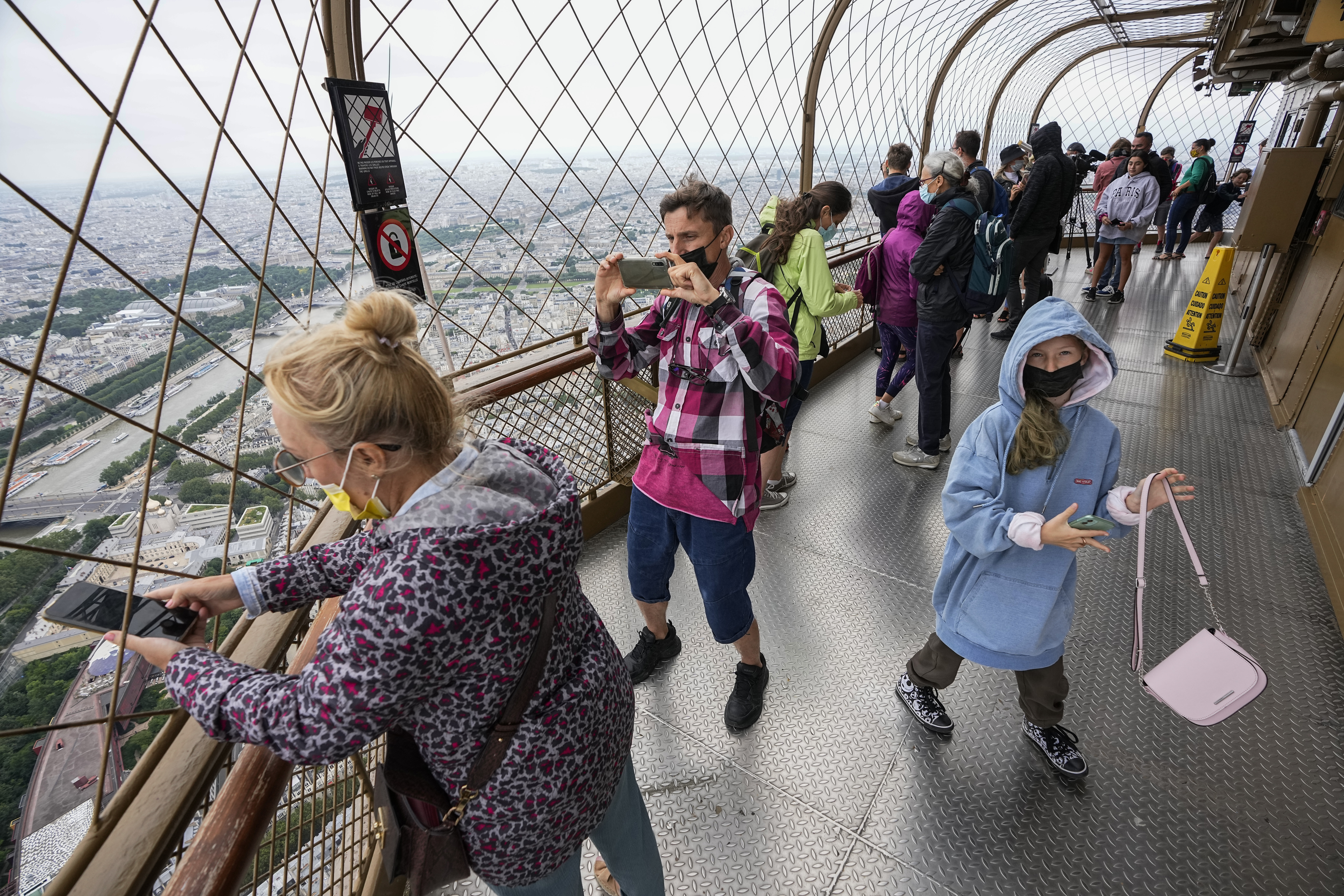 FILE - In this Friday, July 16, 2021 file photo, visitors enjoy the view from top of the Eiffel Tow...