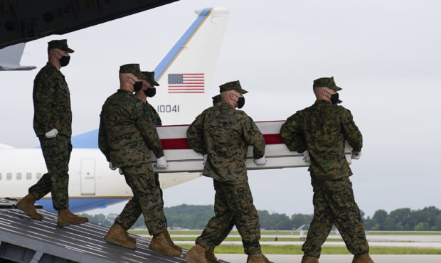 President Joe Biden watches as a carry team moves a transfer case containing the remains of Marine ...