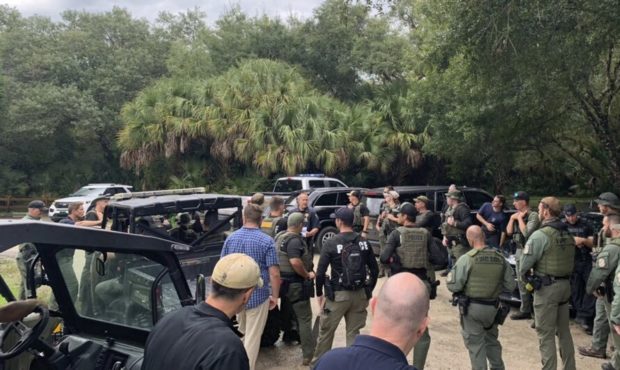 This photo provided by North Port Police Department, law enforcement officials conduct a search of ...