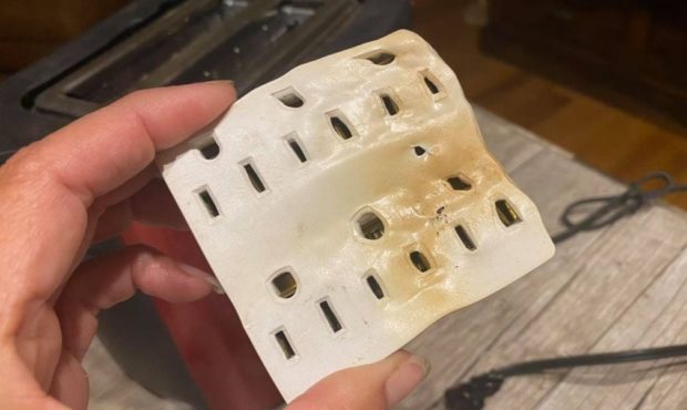KSL Newsradio host Debbie Dujanovic shows the outlet cover that was burning when she walked into he...