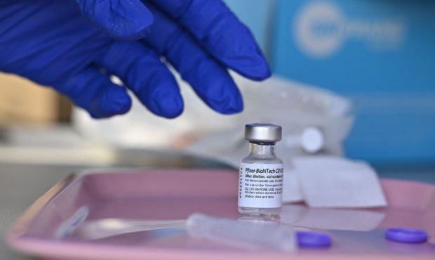 FILE: A nurse reaches for a vial of Pfizer-BioNTech Covid-19 vaccine at a pop up vaccine clinic in ...