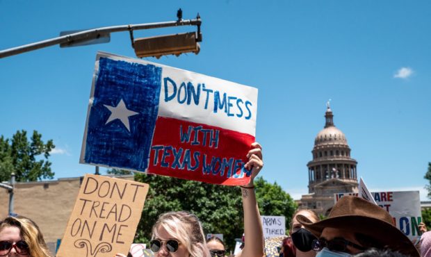 AUSTIN, TX - MAY 29: Protesters hold up signs as they march down Congress Ave at a protest outside ...