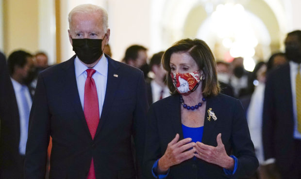 President Joe Biden walks with House Speaker Nancy Pelosi of Calif., on Capitol Hill in Washington,...