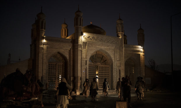 Taliban fighters walk at the entrance of the Eidgah Mosque after an explosion in Kabul, Afghanistan...