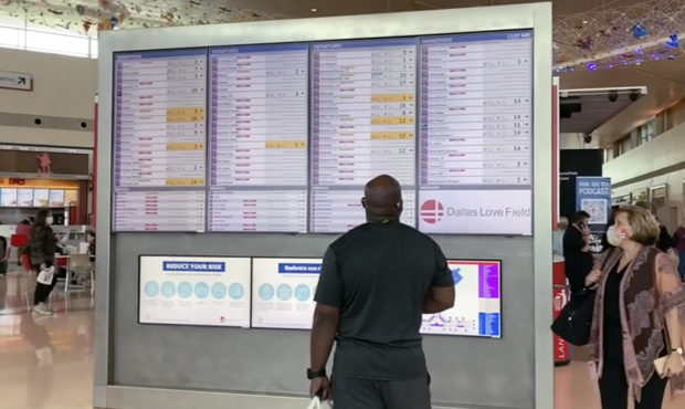 In this frame grab from cellphone video, passengers look for information on their flights, Sunday, ...