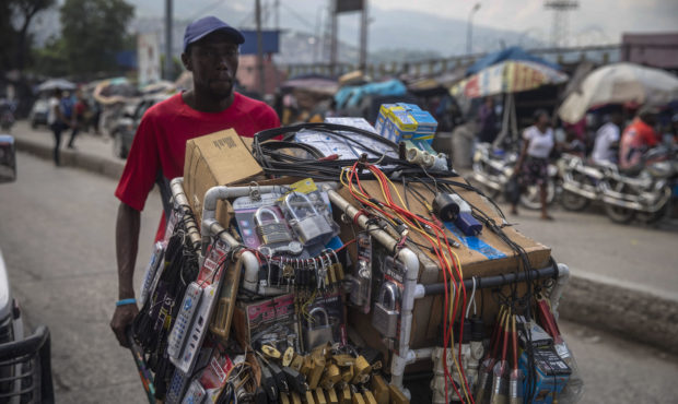 A street vendor moves his merchandise in a wheelbarrow in Port-au-Prince, Haiti, Sunday, Oct. 17, 2...