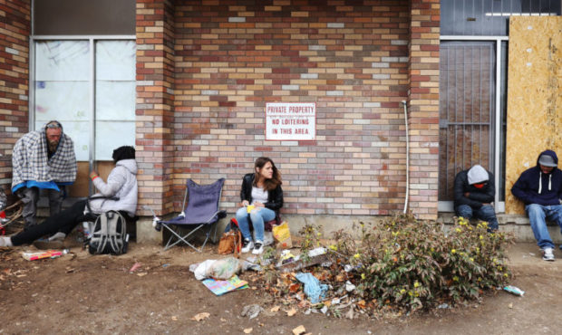 Homeless persons sit in a closed business on North Temple in Salt Lake City on Tuesday, April 6, 20...