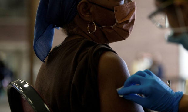 A nurse sanitizes a patient's arm before administering a coronavirus disease (COVID-19) vaccine boo...