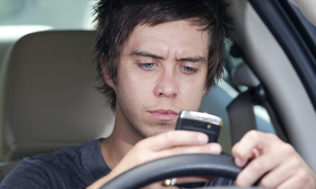 teen driving car while texting is pictured...